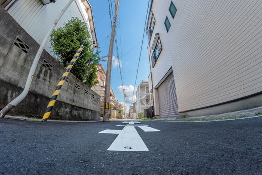 A fish eye shot taken from ground level on a small street in Japan.