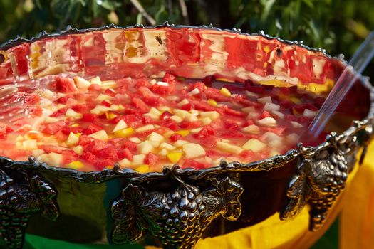 mixed punch with fresh fruits in metal bowl