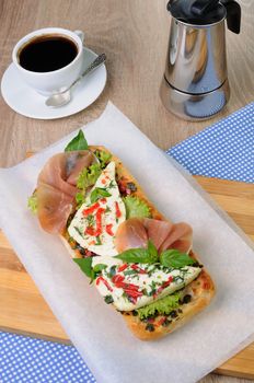 Sandwich with mozzarella and jamon on ciabatta with a cup of coffee