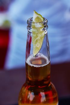 Beautiful ice cold beer in a bottle with a wedge of fresh lime