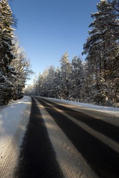   the highway in a winter season. the road is covered with snow