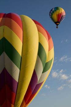 Colorful hot air balloons launching against a blue sky
