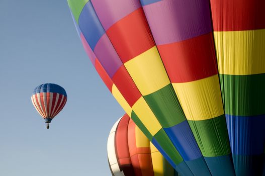 Colorful hot air balloons launching against a blue sky