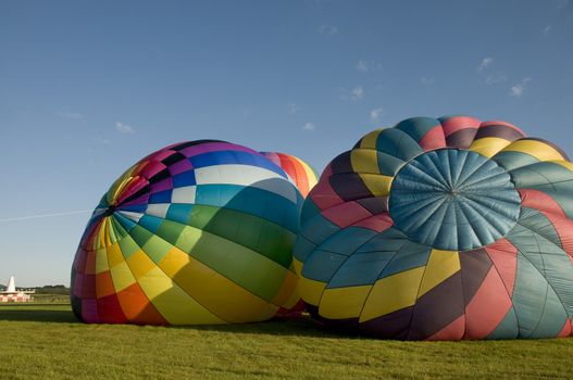 Two hot-air balloons inflating on the ground