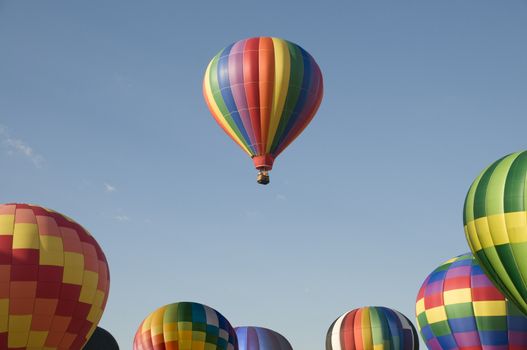 A single hot-air balloon floating above others at a balloon festival