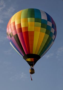 Colorful hot air balloon launching against a blue sky