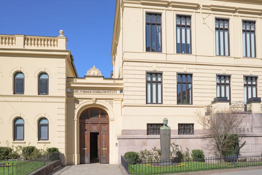 Entrance of The Norwegian Nobel Institute in Oslo with a bust of Alfred Nobel in the foreground.