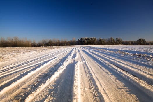 the road covered with snow in a winter season