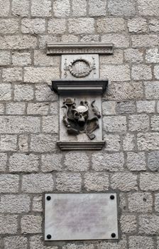   an ancient stone sign: a plate with the coat of arms of the former drugstore, one of the first in Europe (1326). City of Kotor, Montenegro