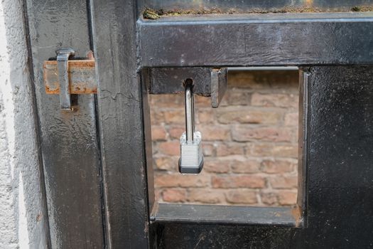 metal gate locked and secured by metal padlock