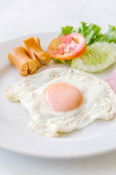Fried eggs and sausage on a white  plate
