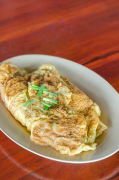 Thai omelette  or scrambled eggs with spring onion on dish