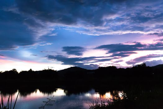 Reflection magic of colour sky and cloud in the river at twilight time.