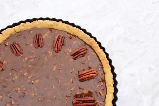 Close-up of whole pecan nuts decorating the top of an unbaked pecan pie