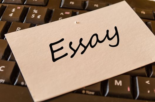 Essay text concept note on dark keyboard background