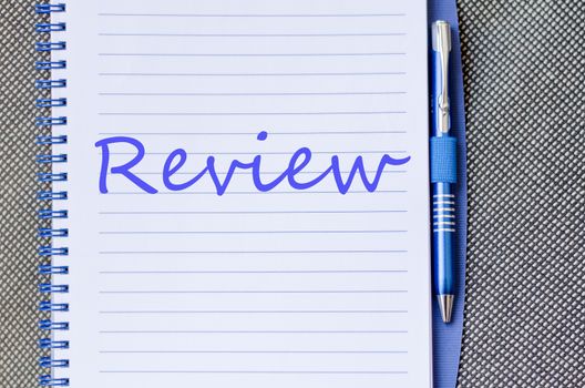 Notepad and pen on wooden background and text concept