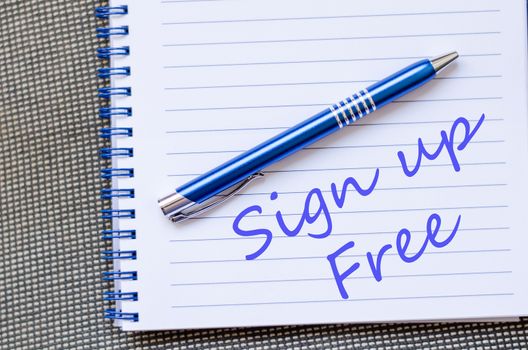 Notepad and pen on wooden background and text concept