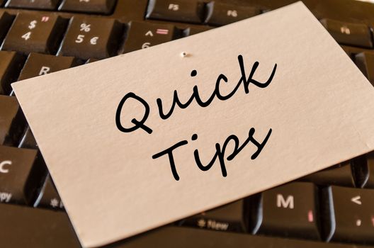 Quick tips text concept note on dark keyboard background