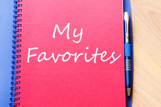 Notepad and pen on wooden background and text concept