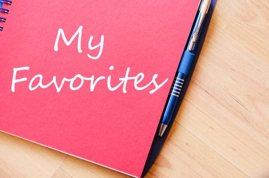 Notepad and pen on wooden background and text concept