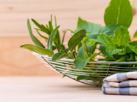 Fresh green herbs harvest from garden in the basket on wooden  background .