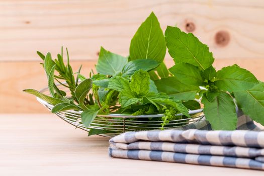 Fresh green herbs harvest from garden in the basket on wooden  background .