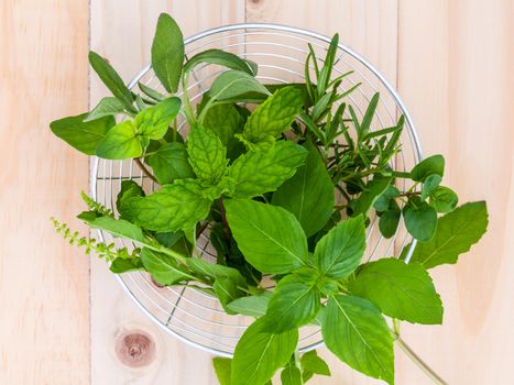 Fresh green herbs harvest from garden in the basket on wooden  background .