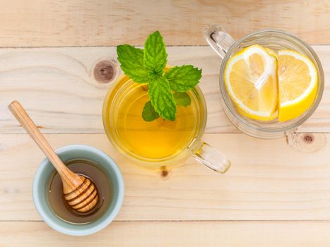 Cup of herbal tea with fresh green mint ,honey and lemon on wooden background.