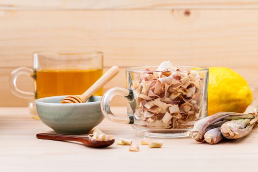 Cup of herbal tea with dried lemon grass ,honey and lemon on wooden background.