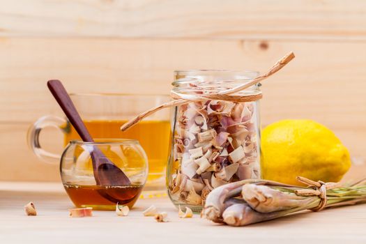 Cup of herbal tea with dried lemon grass ,honey and lemon on wooden background.