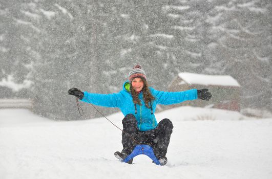 girl on  sledge downhill in wintertime