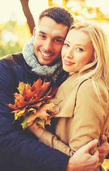 holidays, love, relationship and dating concept - romantic couple in the autumn park