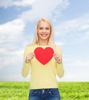 happiness, health and love concept - smiling woman with red heart