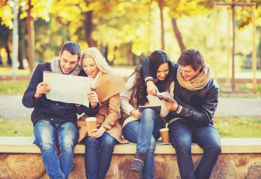 holidays and tourism, navigation concept - group of friends or couples with tourist map and tablet pc computer in autumn park