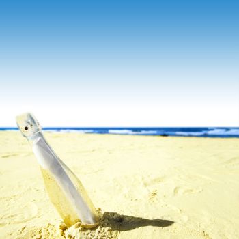 Message in a bottle on sand.