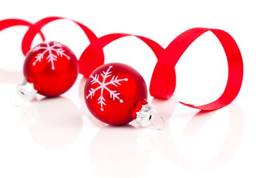 two red christmas decoration balls with satin ribbon, isolated on white background