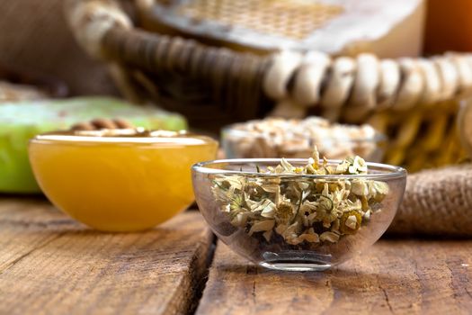 herbal camomile in the glass bowl, on wooden background