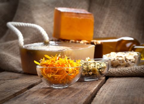 herbal calendula in the glass bowl, on wooden background