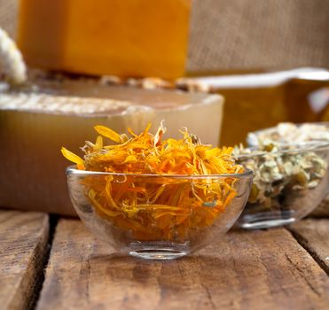 herbal calendula in the glass bowl, on wooden background
