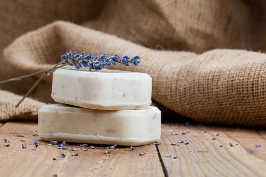 Bars of soap with lavender on a rustic wooden background