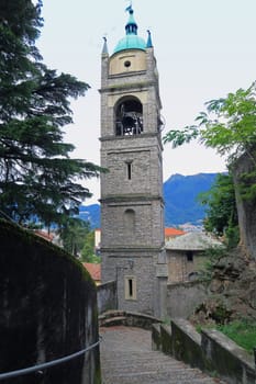 Bell tower of the fourteenth century saw a steep street typical of Bellano, Lake Como, Italy