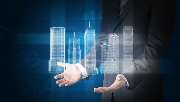 Businessman with 3d model of city in hands on abstract blue background with graphs