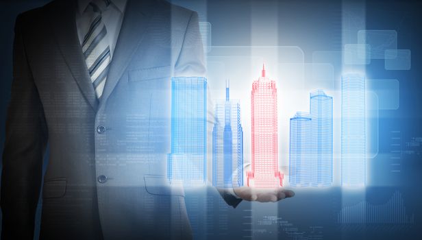 Businessman with colorful 3d model of city in hands on abstract blue background with graphs