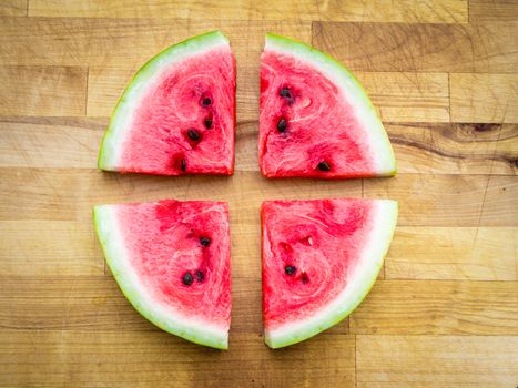 Watermelon slices arranged in a circle shape, fresh fruit rawfood still life on wooden board
