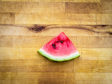 Watermelon slice arranged on a wooden board, raw food fruit stilllife with copyspace