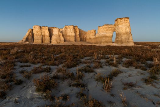 A horizontal landscape photography image of Monument Rocks in Kansas before sunset.  They are also known as Chalk Pyramids. 