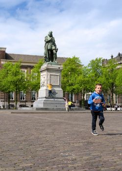 The Hague, Netherlands - May 8, 2015: Children at Het Plein in The Hague's city centre, with the statue of William the Silent in the middle. on May 8, 2015.