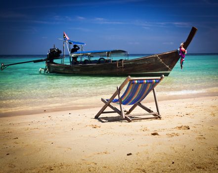 Exotic beach holiday background with beach chair and long tail boat - Thailand ocean landscape