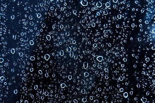 Blue water rain drops on the glass. Background picture.