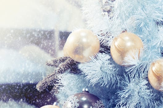 Christmas tree with christmas baubles covered with snow.